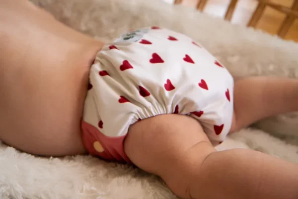 ett barn i en tygblöja med hjärtan på