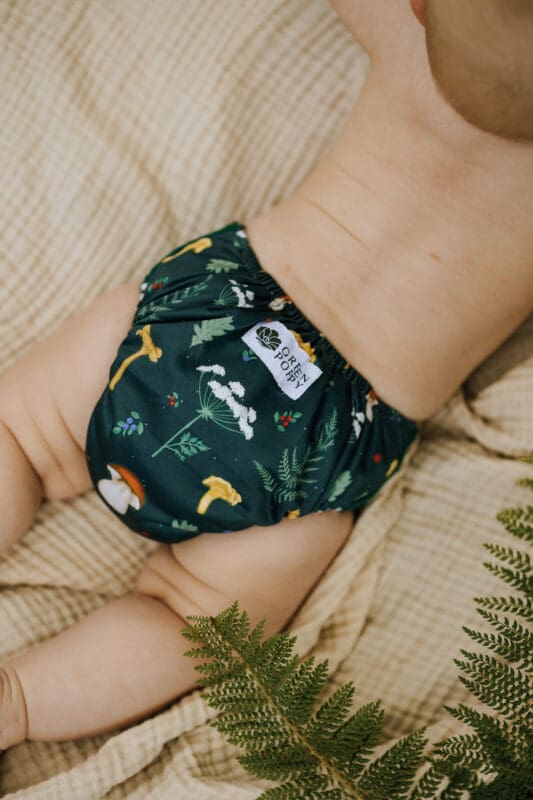 ett barn på en filt med en tygblöja